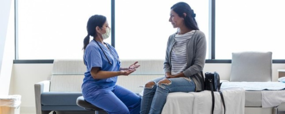 Doctor and patient talking in exam room.