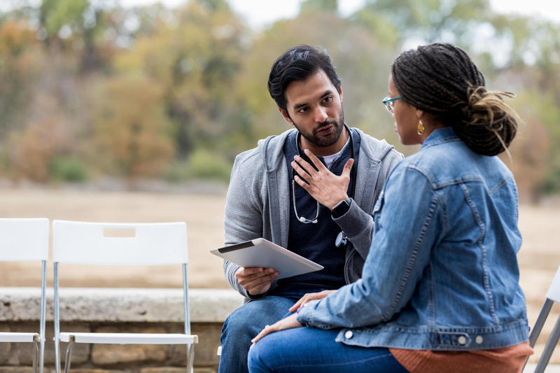 healthcare worker talking with patient outside